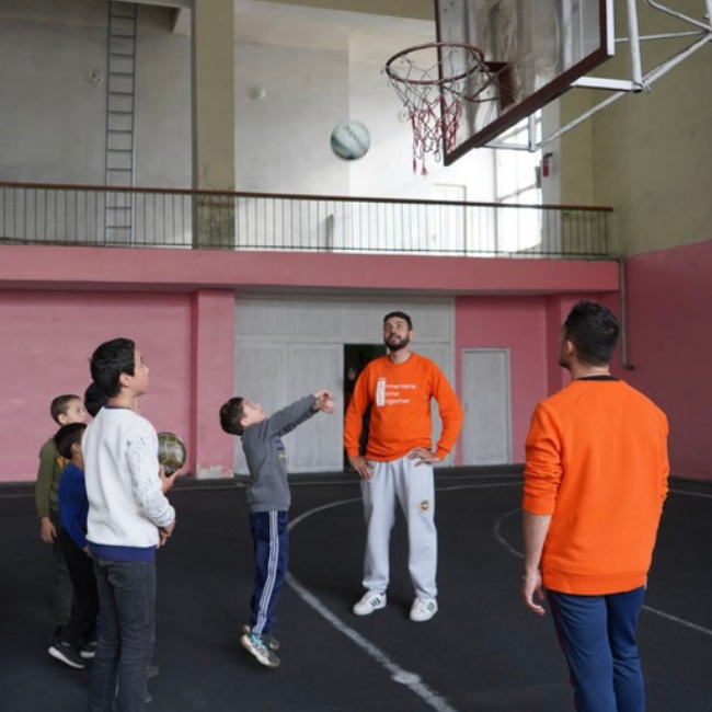 Volunteers playing basketball with children from Hrazdan